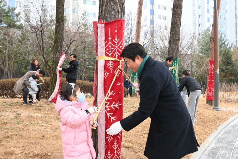 1-3. 조용익 부천시장이 어린이와 함께 수목보호대 입히고 있다..JPG